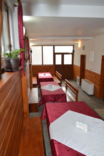 a room with four tables with red and white sheets at Baba Dora Guesthouse in Dobrinishte