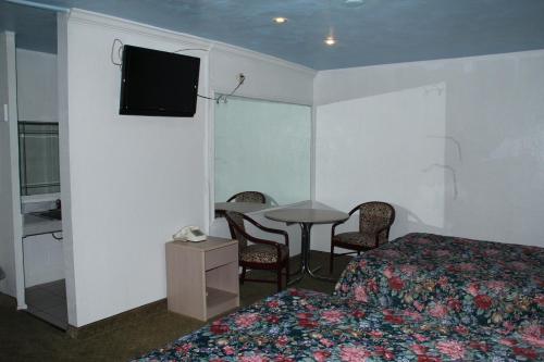 a hotel room with a bed and a table and a television at Choice Inn San Antonio in San Antonio