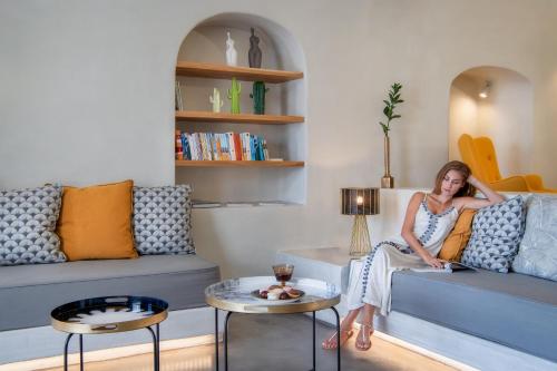 a woman sitting on a couch in a living room at Halcyon Days Suites in Pirgos