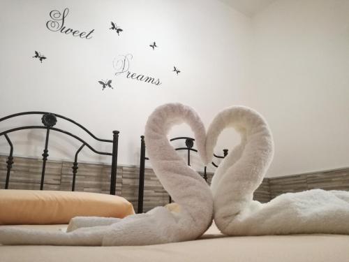 two swans made out of towels sitting on a bed at Casa Solemare in Torre Lapillo