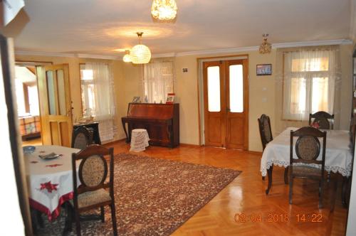 - un salon avec une table et un piano dans l'établissement Hotel Kharabadze, à Koutaïssi