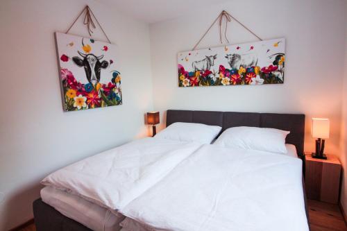 a bedroom with a bed with two pictures on the wall at Haus Haslach in Elsbethen