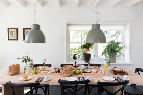 a dining room with a table with food on it at B&B De Beiert in Delden