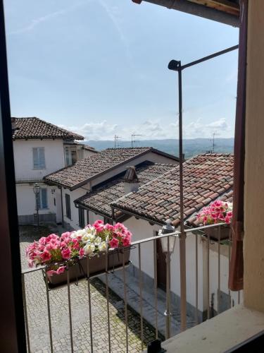 a balcony with flowers on the roofs of buildings at Raviola e Tajarin in Verduno