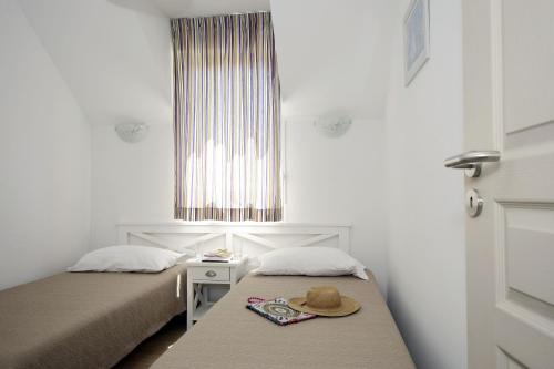 a bedroom with two beds and a hat on a bench at Résidence Odalys - Les Coteaux de Sarlat in Sarlat-la-Canéda