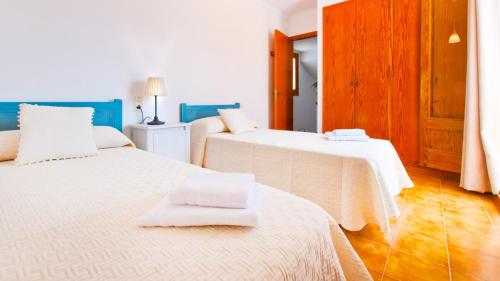 Un dormitorio con dos camas con sábanas blancas. en E028 Gavines by Mallorca Villa Selection, en Playa de Muro