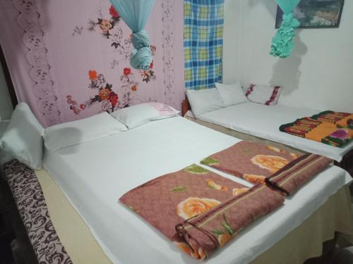 two beds in a room with a blanket on them at Damsen Homestay Ella in Ella