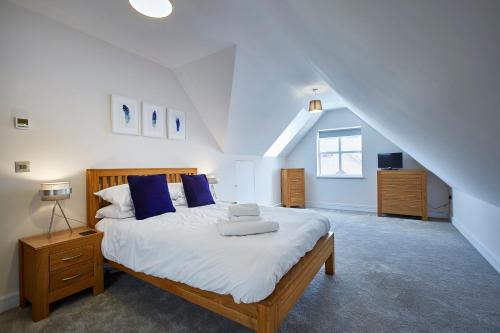 um quarto com uma cama grande e almofadas azuis em Imperial Court By Viridian Apartments em Maidenhead