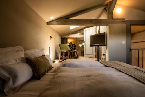 a bedroom with a large bed and a tv at One Suite Hotel - Zollhaus in Bern