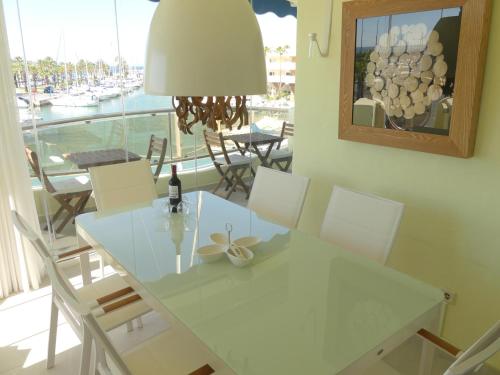 ein Esszimmer mit einem weißen Tisch und Stühlen sowie einem Fenster in der Unterkunft Benalmadena Costa Sol Holiday Rentals in Benalmádena