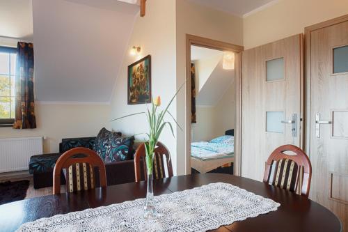 a dining room with a table and chairs and a couch at Kwatery Prywatne Dzika Roza in Darłowo