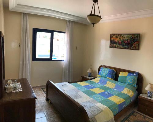 een slaapkamer met een bed en een raam bij Appartement Palm Beach in Mohammedia