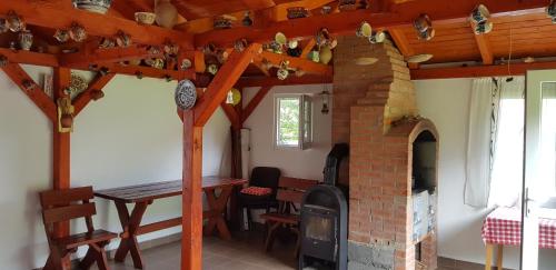 a room with a brick fireplace and a table and a dining room at Korondi Pisztrangos in Corund