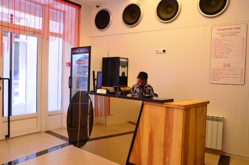 a man is sitting at a counter in a room at Music Hostel in Poltava