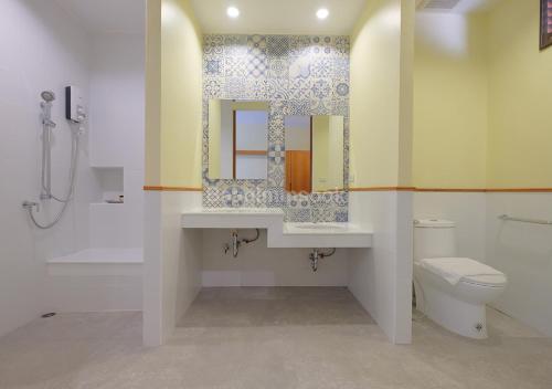 a bathroom with a sink and a toilet and a mirror at Baan Imm Sook Resort in Chao Lao Beach