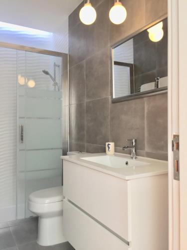 a bathroom with a sink and a toilet and a mirror at Alvor Terrace Villa in Alvor