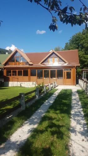 a large wooden house with a fence in front of it at Lumber Apartments Kolašin in Kolašin