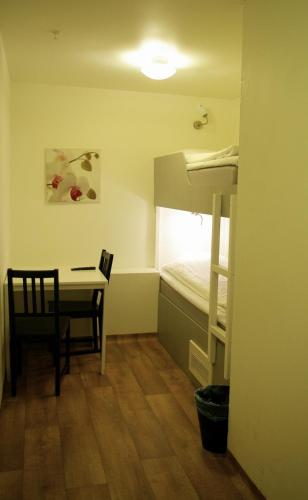 a small room with a desk and a bunk bed at Hotell Centralstation in Uppsala