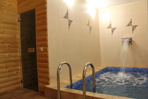 baño con bañera de hidromasaje y fuente de agua en Dialog Hotel, en Najodka