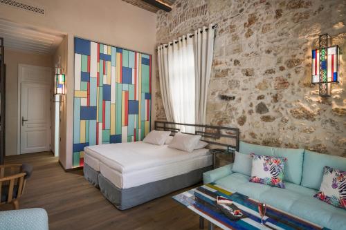 a bedroom with a bed and a stone wall at Ambassadors Residence Boutique Hotel in Chania