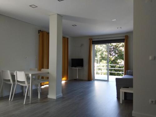 a living room with a table and chairs and a tv at Casas do Caminho Velho in Ribeira de Pena