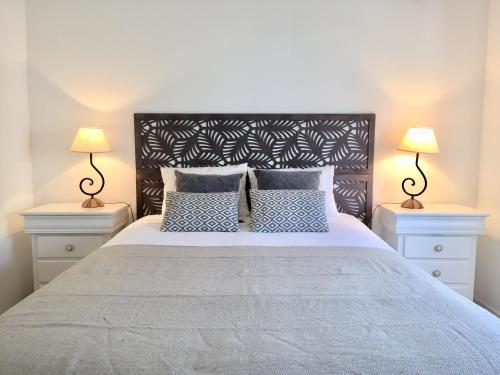 a bedroom with a large bed with blue and white pillows at Alvor Terrace Villa in Alvor