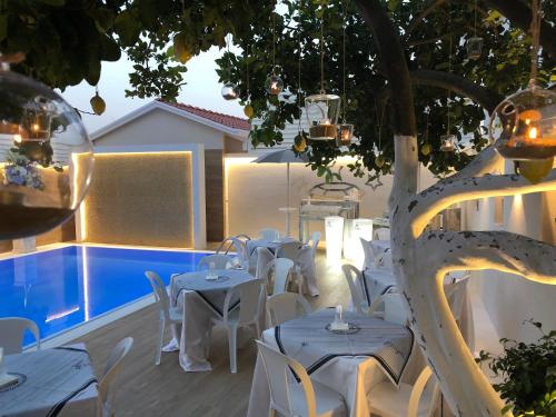 eine Terrasse mit Tischen und Stühlen neben einem Pool in der Unterkunft Hotel Smeraldo in Qualiano
