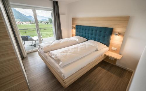 מיטה או מיטות בחדר ב-Im Achtal, Mehr als Ferienwohnungen