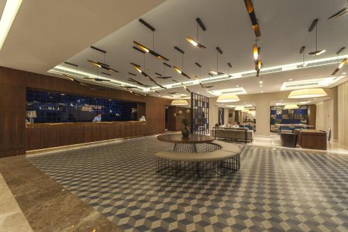 a lobby with a table and chairs in a building at Le Bleu Hotel & Resort Kusadasi in Kusadası