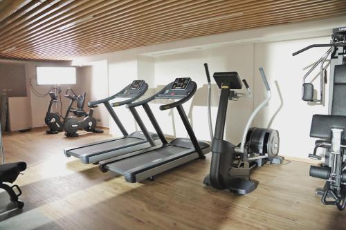 a gym with several tread machines in a room at Novotel Mohammedia in Mohammedia