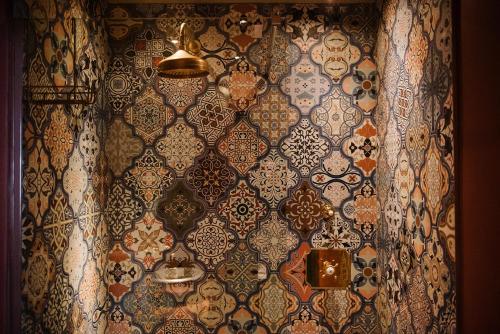 a room with a wall covered in ornate wallpaper at Le Petit Chateau & William de Percy in Otterburn
