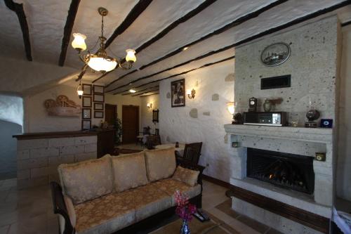 a living room with a couch and a fireplace at Alacati Koclu Konagi Hotel in Alacati