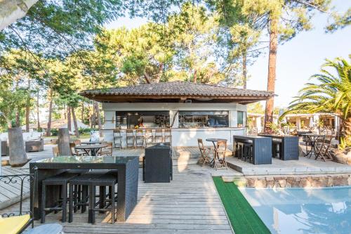 een patio met tafels en stoelen naast een zwembad bij Kilina in Porto-Vecchio