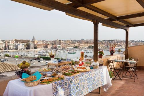 a buffet table on a balcony with a view of a harbor at Terra&Mare B&B in Siracusa