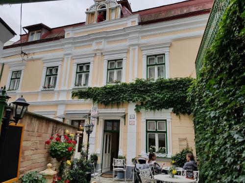budynek, przed którym siedzą ludzie przy stołach w obiekcie Villa Vodicka w Pieszczanach