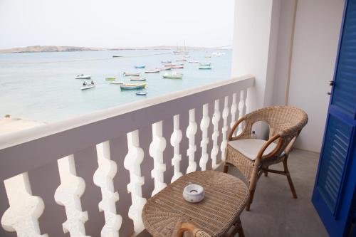 a balcony with chairs and boats in the water at Nos Kasa in Sal Rei