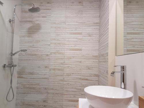 a bathroom with a white sink and a shower at Apartamentos La Senda de Llanes in Llanes