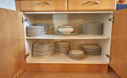a cupboard filled with plates and bowls at Chalet Birkenhof in Saalbach Hinterglemm