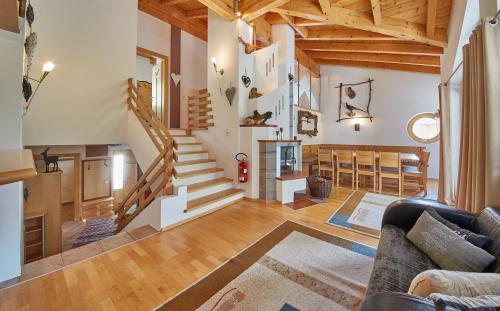a living room with a couch and a staircase at Chalet Birkenhof in Saalbach Hinterglemm