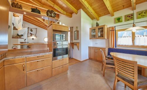 una cocina con armarios de madera, mesa y sillas en Chalet Birkenhof en Saalbach Hinterglemm