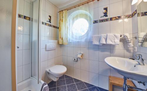 a bathroom with a toilet and a sink and a shower at Chalet Birkenhof in Saalbach Hinterglemm