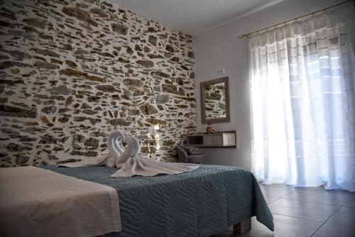 sypialnia z kamienną ścianą i łóżkiem w obiekcie Villa Anna w mieście Balíon