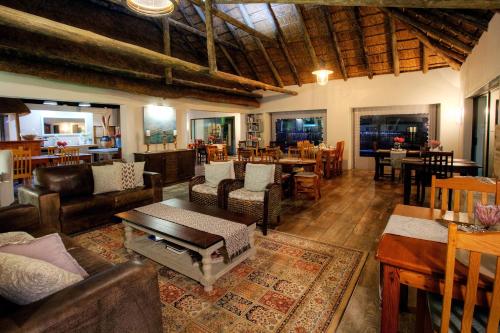 a living room with couches and chairs and a table at De Old Drift Guest Farm in Addo