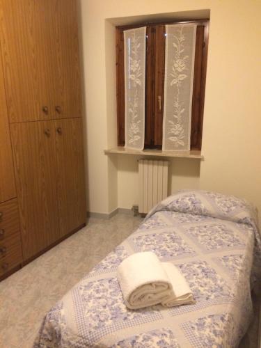 Un dormitorio con una cama con una toalla. en Locazione turistica Isabella en Castelnuovo del Garda