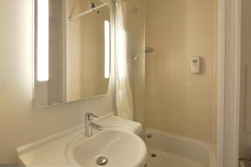a white bathroom with a sink and a shower at B&B HOTEL Bourges 2 in Bourges