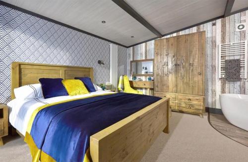 a bedroom with a large bed and a bath tub at Whitecliff Bay Holiday Park in Bembridge