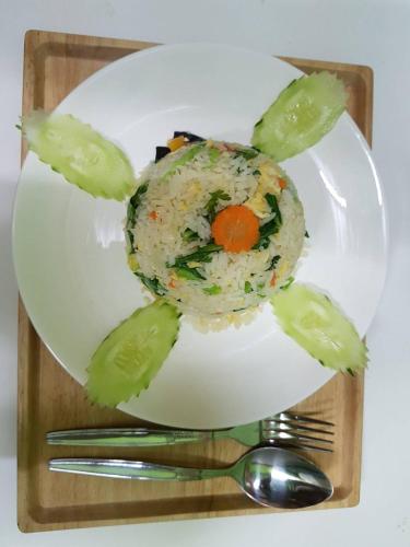 a plate of food with rice and vegetables on it at Amaretto Hostel in Surat Thani