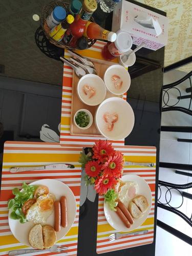 two tables with plates of food on them at Amaretto Hostel in Surat Thani