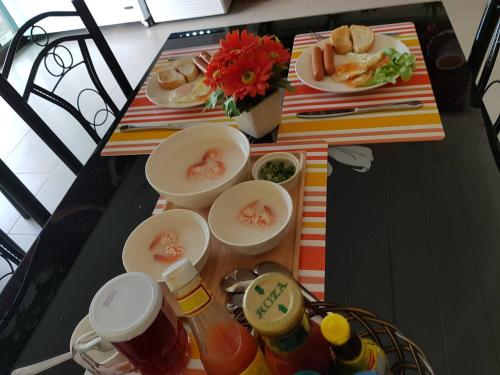 a table topped with plates of food and condiments at Amaretto Hostel in Surat Thani