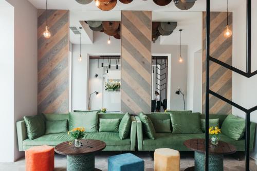 salon z zieloną kanapą i dwoma stołami w obiekcie Avena Boutique Hotel by Artery Hotels w Krakowie